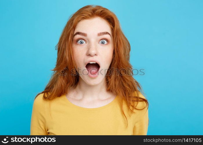 Close up Portrait young beautiful attractive redhair girl shocking with something. Blue Pastel Background. Copy space.