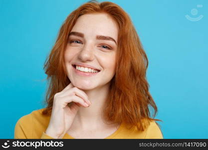 Close up Portrait young beautiful attractive redhair girl smiling looking at camera. Blue Pastel Background.