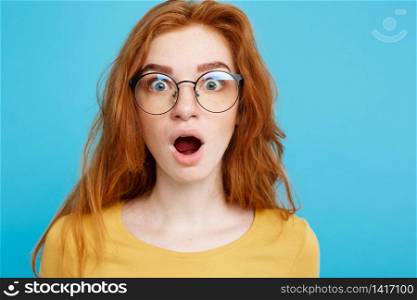 Close up Portrait young beautiful attractive redhair girl with eyeglass shocking with something. Blue Pastel Background. Copy space.