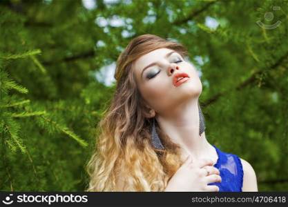Close up Portrait, Young beautiful blonde woman posing outdoors in summer green park