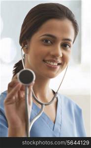 Close-up portrait young female surgeon holding stethoscope