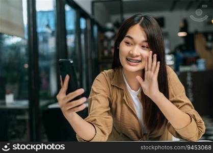Close up, Portrait young pretty woman enjoy to talk and smile while video call on smartphone at cafe