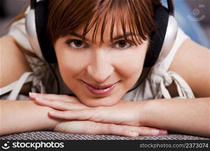 Close-up portrqit of a beautiful young woman listening music with headphones