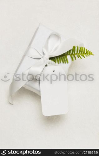 close up present box empty tag green leaf isolated white background