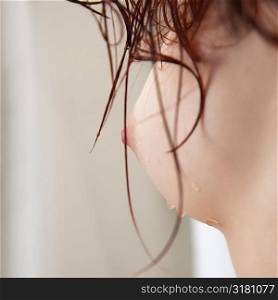Close up profile of young woman&acute;s wet naked breast.