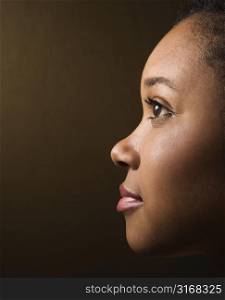 Close-up profile portrait of serious African-American young adult female.