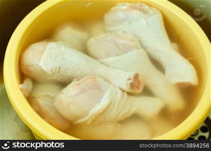 Close up raw chicken meat drumstick in water, washing cleaning and food preparing.