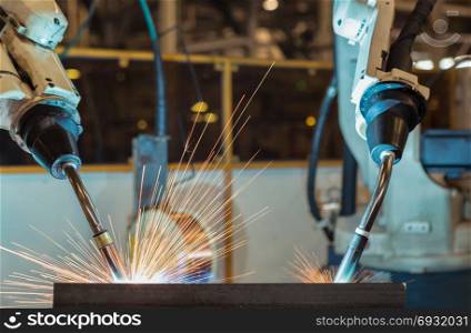 Close up robots are welding in car factory