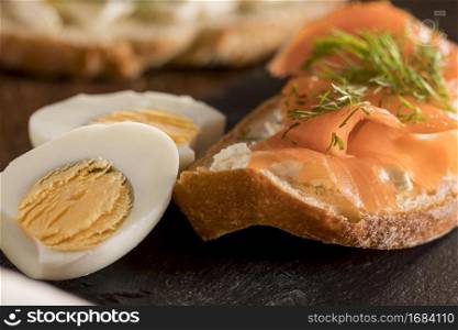 close up sandwich slate with salmon hard boiled egg
