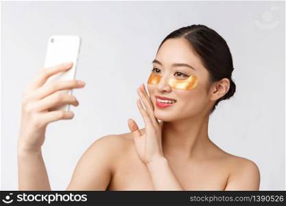 Close up selfie of beautiful happy woman with eye mask on face.Woman with eyes mask taking selfie with mobile phone at home enjoying relaxation.. Close up selfie of beautiful happy woman with eye mask on face.Woman with eyes mask taking selfie with mobile phone at home enjoying relaxation and
