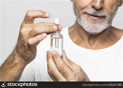 close up senior man holding serum