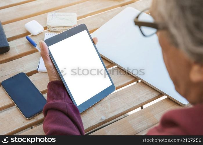 close up senior man looking digital tablet with blank white screen wooden table