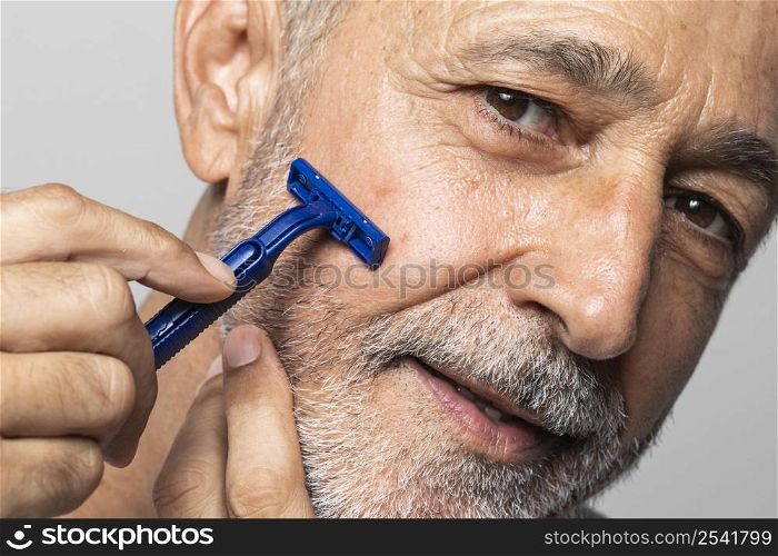 close up senior man shaving