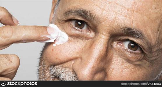close up senior man using face cream
