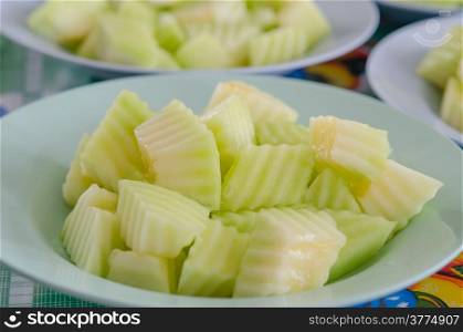 close up several cut green melon on the shallow dish. green melon
