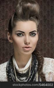 close-up shoot of fashion creative brunette girl posing with elegant hair-style and strong make-up, white lace shirt and a lot of necklaces&#xA;
