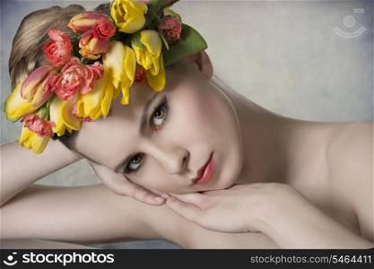 close-up shoot of sexy naked girl with spring style and floral garland. Looking in camera with colorful make-up and fresh skin