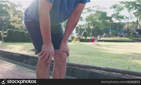 Close up shot asian man doing knee warm up at public park, joint ligament bone problem, ankle sprain sport injury prevention, healthy active lifestyle, warm up before running, hot sunny day