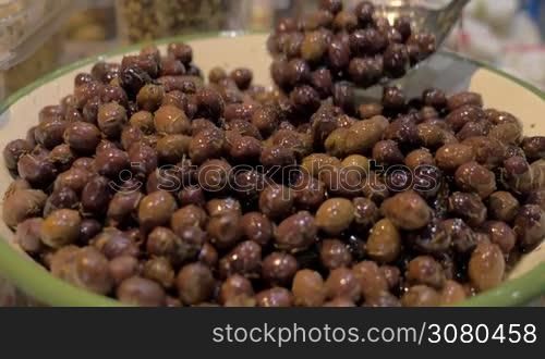 Close-up shot of a big bowl full with marinated olives at food market