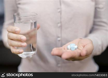 Close-up shot of a hand holding two white pills.