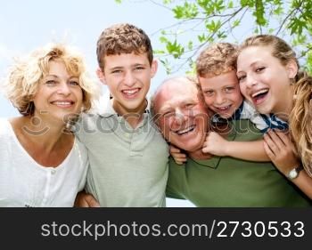 Close-up shot of a happy family in the park looking at camera