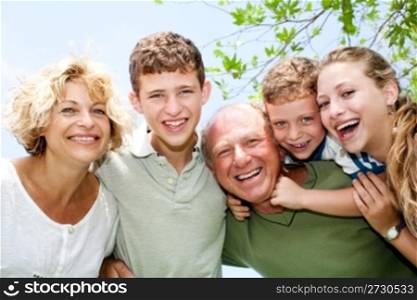 Close-up shot of a happy family in the park looking at camera
