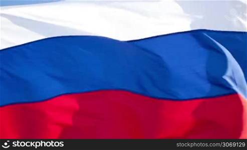 Close-up shot of a Russian flag on the flagpole waving in the wind