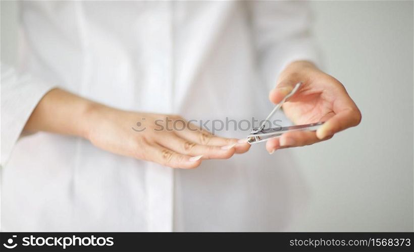close up shot of a woman cutting her nails with shallow depth of field, focus on nail clipper