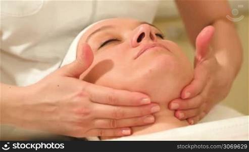 Close-up shot of a woman getting facial massage at beauty treatment salon