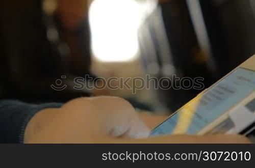 Close-up shot of a woman passenger in the airplane typing sms on the smart phone. After sending message she blocking cell and taking it away