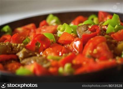 Close-up shot of appetizing dish with meat and vegetables. bright vibrant colors of red tomatoes and green pepper