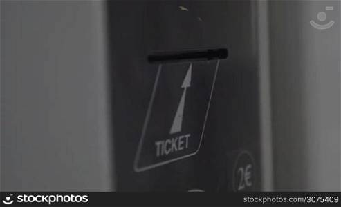 Close-up shot of child hand getting ticket from ticket-machine