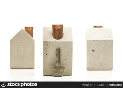 Close up Shot of Conceptual Key with Three Miniature Homes in Different Positions, Isolated on White.
