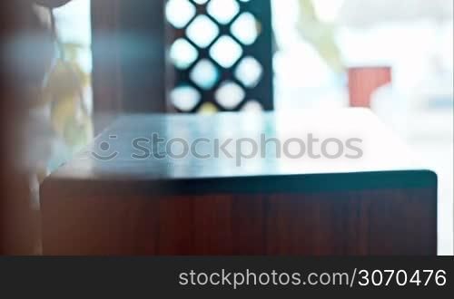 Close-up shot of female hands putting two white clean towels on small table in hotel or beauty spa