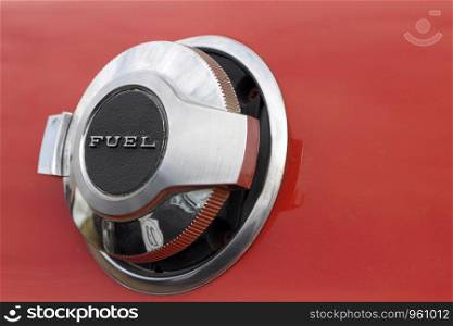 Close up shot of fuel tank cap on red car.