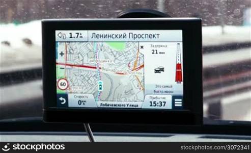 Close-up shot of GPS device fixed on windscreen showing different parameters of driving
