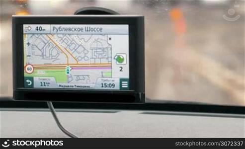 Close-up shot of GPS device showing car moving on Rublevskoye Shosse. Navigation makes driving in city easy
