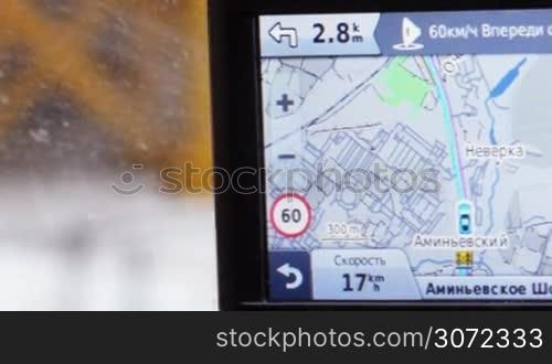 Close-up shot of GPS monitor in moving car. It displaying route, speed of driving and distance to nearest turning