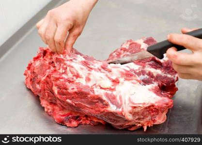 close up shot of hands dressing meat with knife