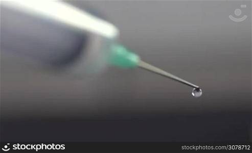 Close up shot of hypodermic needle dripping