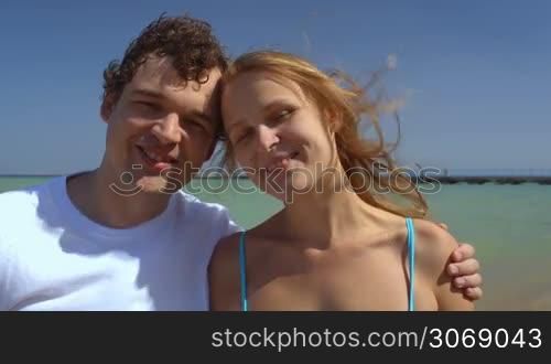 Close-up shot of loving couple being happy together. Sea and sky background