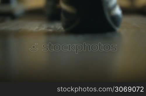 Close-up shot of male feet walking on the treadmill in the fitness center