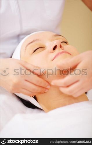 Close-up shot of massage therapist doing a facial massage at beauty treatment salon