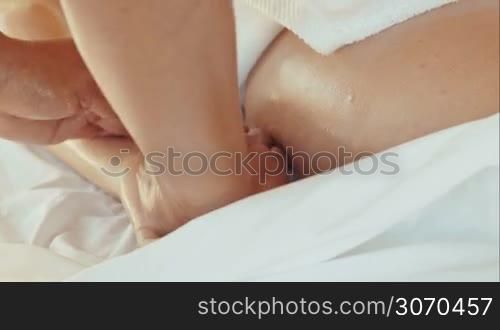 Close-up shot of massage therapist giving a woman massage of palm and fingers