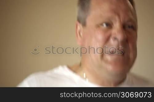 Close-up shot of mature man running on treadmill being tired and breathing deeply