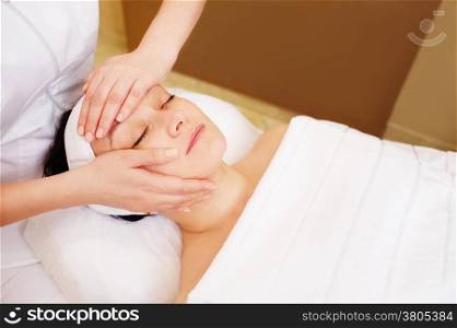 Close-up shot of relaxed woman taking treatments of facial massage in at beauty spa