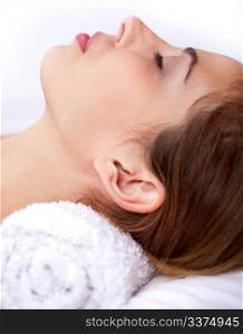 Close up shot of Sleeping young woman in the spa over white background
