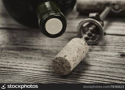 Close up shot of top of wine bottle cork with antique opener in background in vintage style. Layout in horizontal format.