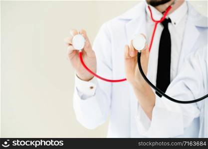 Close up shot of two doctors pointing stethoscope at copy space. Selective focus at front doctors hand.. Close up shot - doctors point stethoscope at space