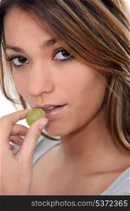 Close-up shot of woman eating grapes